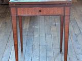 une petite table en bois avec un plateau en verre, posée sur un parquet