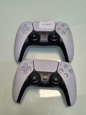 deux manettes de jeux vidéo posées l'une à côté de l'autre sur une table