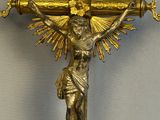 gold crucifix with a sunburst in the middle of it