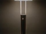 a black lamp on a wooden table in a dark room