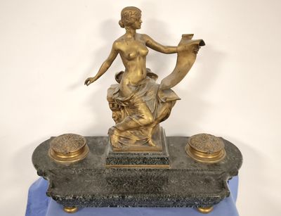 a statue of a woman holding a bird on top of a table
