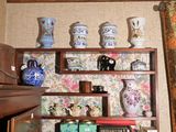 de nombreux vases et livres sur les étagères de cette pièce