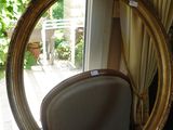 un miroir posé sur une chaise devant une fenêtre