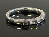 a close up of a diamond ring on a black surface