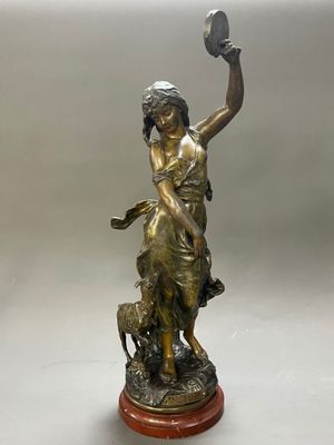 statue en bronze représentant une femme tenant un oiseau et un chien