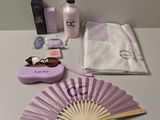une table sur laquelle se trouvent un ventilateur, un flacon de lotion, un sac et d'autres objets