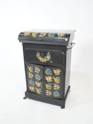 a small black cabinet with a floral design on it