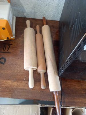 three rolling pin ' s on a wooden table next to a microwave
