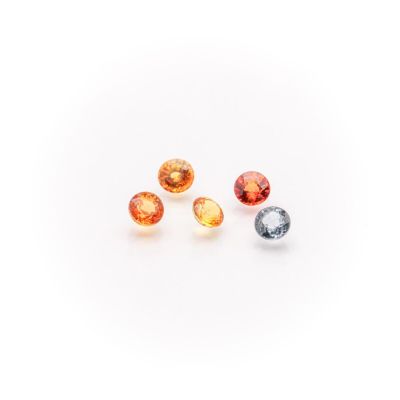 a group of three different colored gems on a white surface