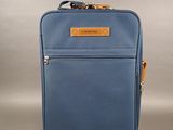 l'arrière d'une valise bleue munie d'une poignée marron