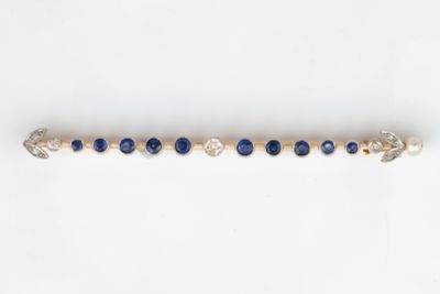 un gros plan d'un bracelet en perles bleues et blanches posé sur une surface blanche