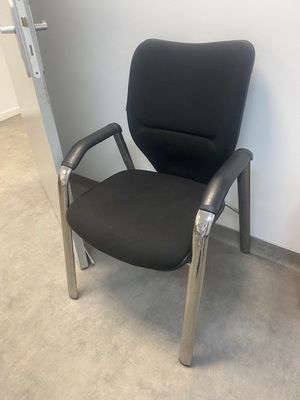 une chaise de bureau noire posée dans un coin d'une pièce