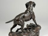 a bronze statue of a dog standing on top of a shoe