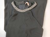 the top of a pair of gray pants with a beaded collar