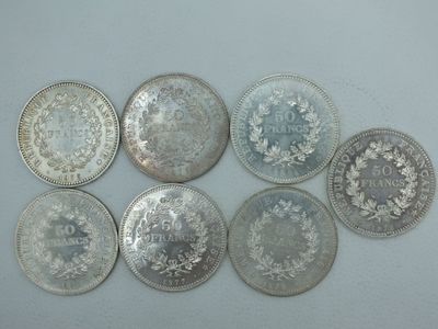 six types différents de pièces d'argent sur une surface blanche