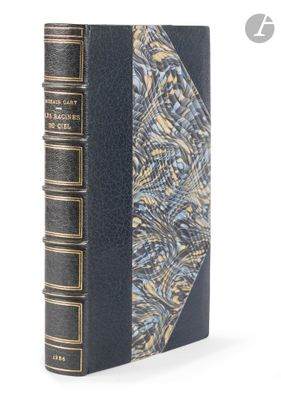 an old book with a blue cover sitting on a white surface