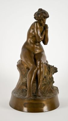 une photo d'une statue en bronze représentant une femme assise sur une souche d'arbre