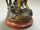 a statue of a man riding a horse with a dog on it