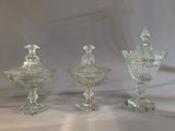three clear glass vases sitting on top of a white table