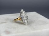 un gros plan d'une bague en or sertie de diamants blancs posée sur un bloc de marbre