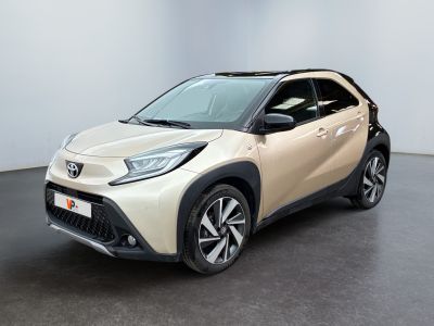 un SUV Toyota C-HR beige garé dans une pièce blanche