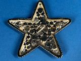 a close up of a metal star on a blue surface