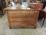 une commode en bois dans une pièce remplie de meubles