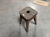 un petit tabouret en bois percé d'un trou