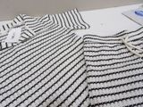 a crocheted sweater on a table next to a pair of scissors