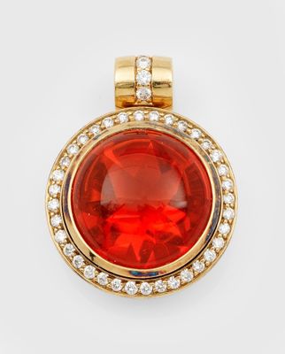 a red stone and diamond pendant on a white background