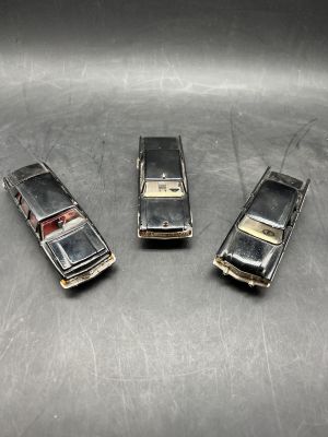 three old model cars that are sitting on a table