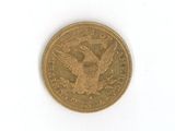 a gold coin with an eagle on it on a white surface