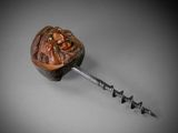a close up of a bottle opener with a wooden handle on a table