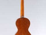 an old wooden guitar hanging from a string on a white background