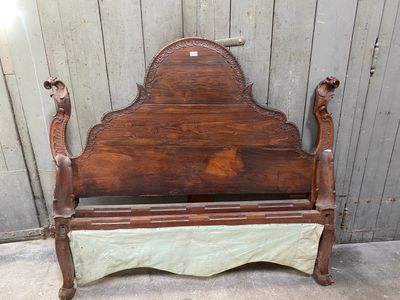 a bed with a wooden headboard and foot board in front of a wooden wall