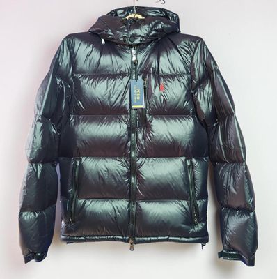 Cette veste est brillante et luisante, et elle est dotée d'une capuche.