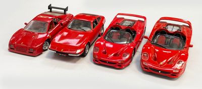 Quatre petites voitures rouges sont alignées en rang sur une surface blanche