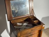 a small wooden table with a mirror on top of it