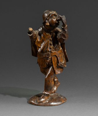 a bronze statue of a man in a hat and coat holding a bag
