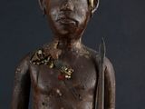 an old wooden statue of a man with headphones holding a ball