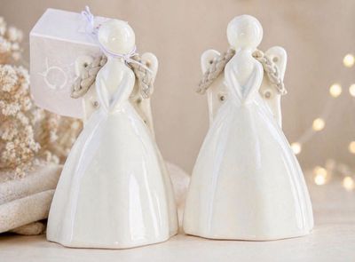 two white angel figurines sitting on a table