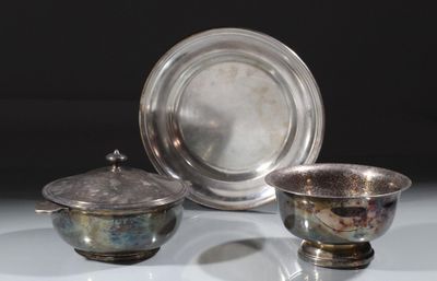 deux plats en argent et un bol en argent posés sur une table