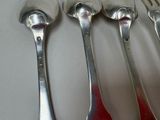five spoons and a fork on a table