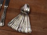 silverware on a wooden table with a knife, spoon, and knife rest