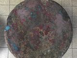 an overhead view of a dirty metal bowl on a tiled floor