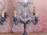 two black candelabs on a table with a pink wall behind them