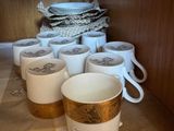 Plusieurs tasses à café sont alignées sur une étagère dans une cuisine