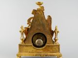 a gold clock that is sitting on top of a table