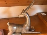 une statue représentant un cerf assis sur une étagère