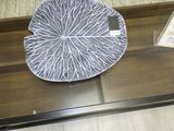 une assiette décorative exposée sur une table en verre